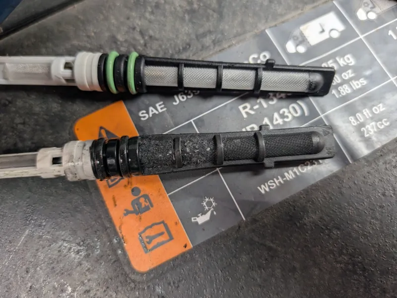 Clogged AC orifice tube (bottom) next to a new one: why the AC was blowing warm
